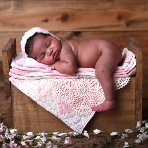 newborn baby in wooden bed