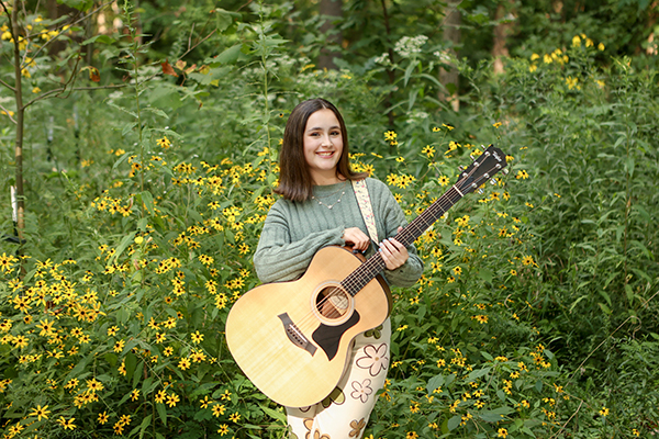 girl with guitar posing for senior pictures at Flowing Well Park in Carmel