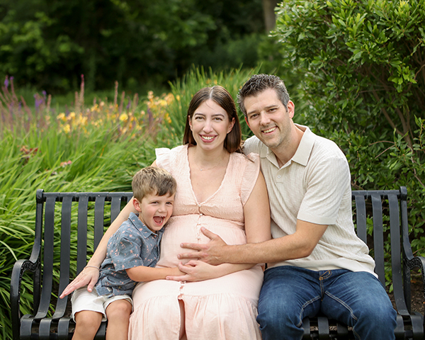 little boy excitedly snuggles mom's pregnant belly