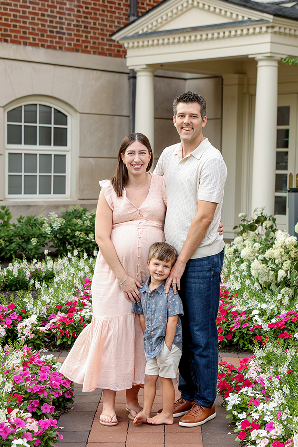 photo family of three in front of flowers 